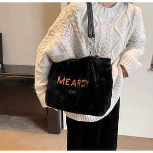Detail of black faux fur tote bag with orange embroidery and leather chain strap