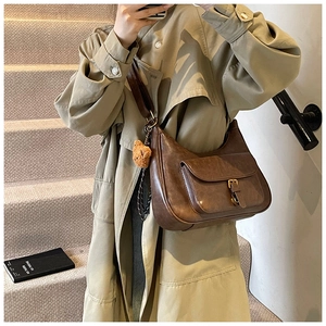 Détail du sac bandoulière demi-lune marron vintage avec poche et breloque ours