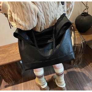 Détail de la poignée en corde tressée et du cuir noir texturé de ce grand sac cabas