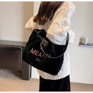 Detail showing plush black faux fur texture and MEARCY Italy embroidery on the tote bag