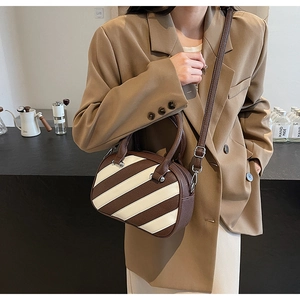 Dettaglio della borsa a tracolla con pelle martellata e design a strisce bicolore
