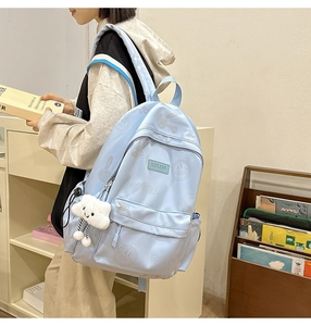Detail of light blue backpack with cute rabbit prints and cloud plush charm decoration