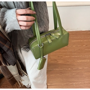 Olive green patent leather handbag with dual long handles and a mini decorative pouch