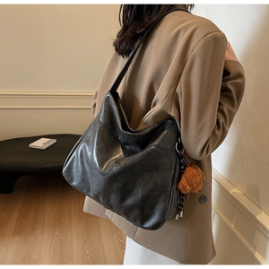 Detail of dark grey vintage faux leather tote bag with a cute brown bear charm