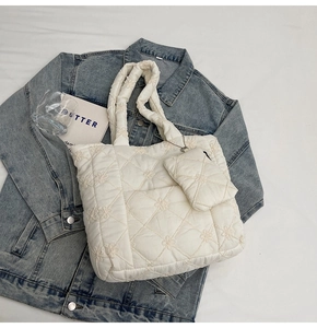 Detailed view of white quilted tote bag with floral embroidery and matching coin purse