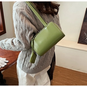 Close-up of green PU leather shoulder bag with matching mini coin purse and long strap