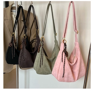 Close-up of suede hobo bags in four colors showing soft matte texture and braided knots