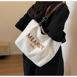 Detail of white plush tote bag featuring MEARCY Italy embroidery and leather strap