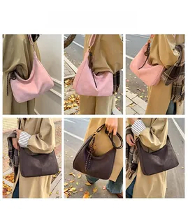 Detailed views of suede hobo bags in pink and brown with tassels for autumn fashion