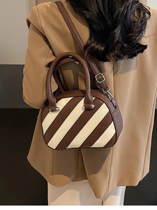 Borsa a mano Boston a righe marroni e bianche con tracolla indossata da modella