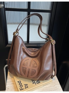 Vintage brown faux leather tote bag with large circular logo and pleated bottom design
