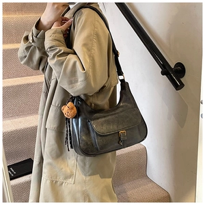 Détail du sac hobo vintage gris avec bandoulière réglable et pendentif ours en peluche
