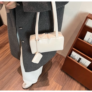 Detail of off-white glossy leather shoulder bag with matching mini coin pouch attachment