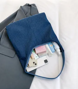 Detail van grote blauwe denim shopper met ruime binnenkant voor cosmetica en telefoon