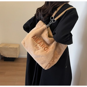 Detail of soft plush tote bag featuring MEAROI Italy embroidery and metal chain strap