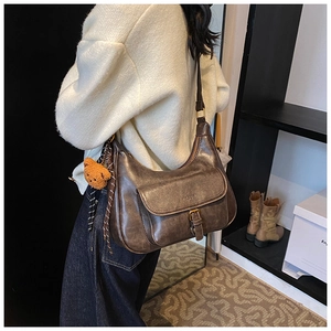 Détail du sac bandoulière rétro en cuir PU marron avec breloque ours et boucle en métal