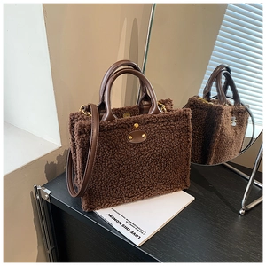Detailed shot of brown plush tote bag texture with leather handle and gold metal clasp