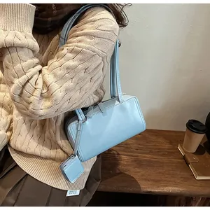 Close-up of light blue leather underarm bag with matching mini coin purse accessory