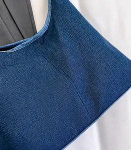 Detail van hoogwaardige navy denim stof met witte spikkels en fijne keperstof textuur