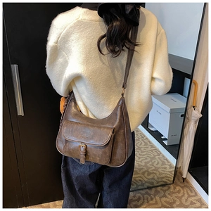 Sac hobo vintage marron avec poche avant et boucle décorative en bronze vieilli