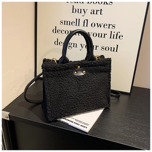 Detail of black faux fur tote bag showing plush texture and smooth leather handles