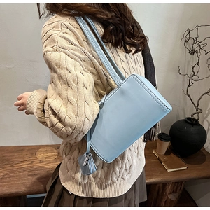 Close-up of light blue rectangle underarm bag with matching mini coin purse on a model