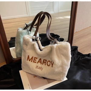 Close-up of white plush tote bag with brown embroidery and faux leather straps