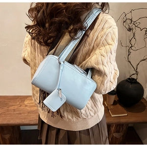 Detail of light blue faux leather shoulder bag with matching mini pouch and dual thin straps