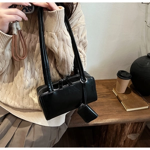 Detail of minimalist black rectangle shoulder bag with a small matching coin purse