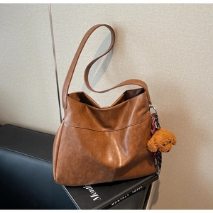Close-up of vintage brown tote bag texture with a cute plush dog charm detail