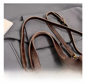 Detail of dark brown vintage bucket bag with metallic logo and textured faux leather handle