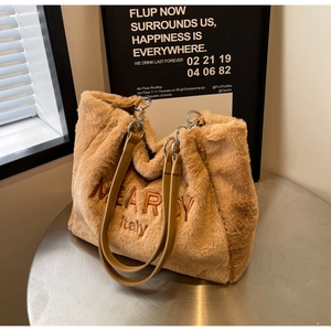 Detail of plush tote bag showing NEARBY embroidery and slim leather shoulder straps