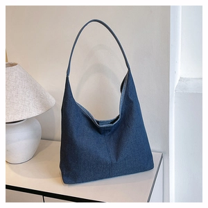 Détail du sac fourre-tout en denim bleu foncé avec texture de tissu sur fond blanc