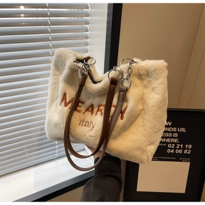 Detailed shot of white plush tote bag with brown MEARDY Italy embroidery and leather straps