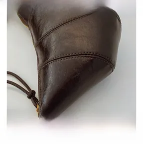 Detail showing the stitching and texture of the brown leather croissant shoulder bag