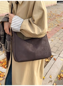 Detail of dark brown vintage hobo bag with stitching, styled for autumn fashion outfit
