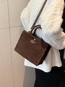 Furry brown plush tote bag with leather handles and gold metal detail worn by model