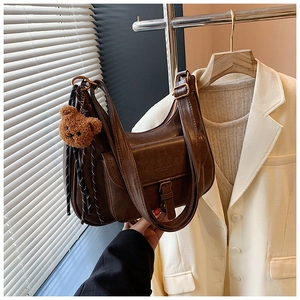 Détail du sac à bandoulière vintage en cuir PU marron avec poche à boucle et ours en peluche