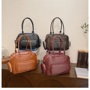 Detail of four retro faux leather handbags in black, brown, and burgundy on a wooden table