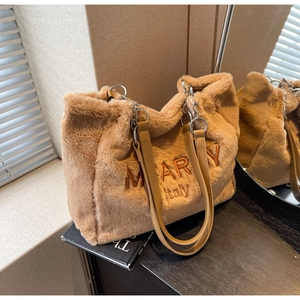 Detail of warm brown plush tote bag showing soft faux fur texture and metal chain straps