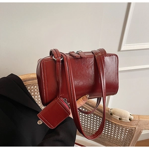 Detail of dark wine red patent leather shoulder bag with detachable mini coin purse