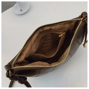 Detail view of the spacious inner compartment and gold zipper of the brown dumpling bag