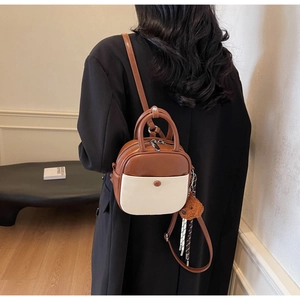 Detailed back view of a retro brown and cream mini handbag with cute plush bear charm