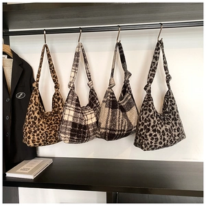Detailed display of plush faux fur hobo bags in leopard and plaid patterns on rack