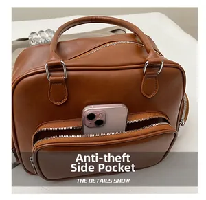 Detail of a brown leather tote showing an anti-theft side pocket with a smartphone inside