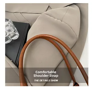 Detail view of the brown leather shoulder strap with premium stitching on a handbag