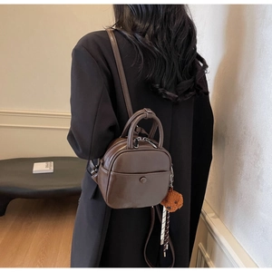 Chocolate brown mini PU leather backpack with cute bear charm shown on model