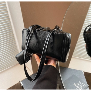 Detail of vintage black leather shoulder bag with glossy finish and matching coin purse
