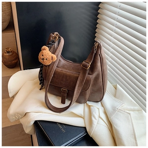 Détail du sac sous l'aisselle marron vintage avec poche à boucle et charm ours en peluche