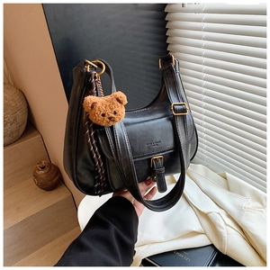Détail du sac demi-lune en cuir PU noir avec boucles dorées et breloque ourson